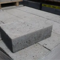 Stos szarych bloczków betonowych, gotowych do budowy. Ściana z bloczków betonowych czeka na swoją kolej.