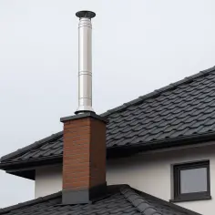 Schemat budowy komina z cegły i stali nierdzewnej na dachu domu.