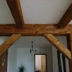 Solidne drewniane belki połączone w solidną konstrukcję, tworząc stylowe przejście.