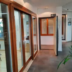 Salon okien i drzwi z drewnianymi ramami, przeszklonymi drzwiami i oknami.